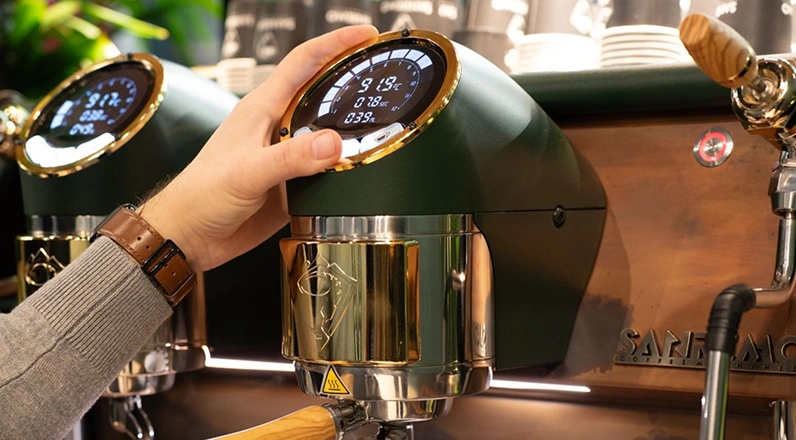 Persona ajustando la máquina de café espresso con pantalla digital