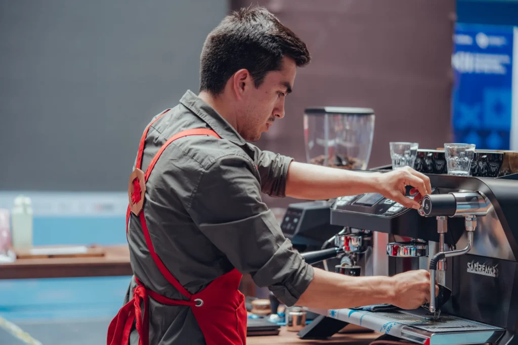 Barista ajustando la máquina de café espresso en una cafetería
