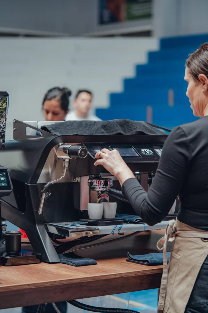 Barista utilizando una cafetera espresso para preparar café en una competencia